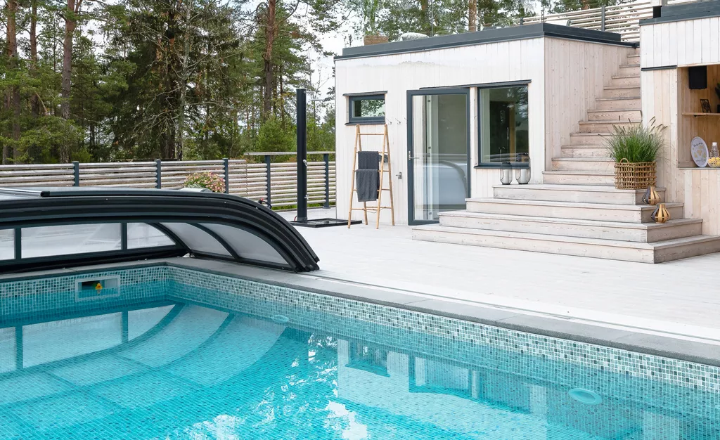 Mosaikpool med turkost vatten och automatiskt hopfällbart pooltak